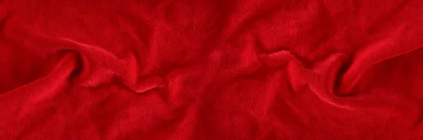 Red velvet texture for postcard or background for design. Red background for Christmas theme or Valentines day, high quality, large format. Abstract texture of draped red velvet.