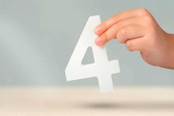 Νούμερο Τέσσερα Στο Χέρι Χέρι Κρατώντας Λευκό Αριθμό Θολή Φόντο — Φωτογραφία Αρχείου