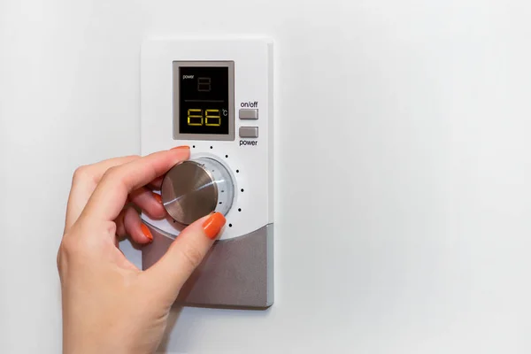 Gas boiler or boiler. A woman regulates the temperature with a temperature controller. Setting the room temperature by adjusting the gas boiler. Household concept, heating season