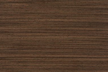 Texture of wenge wood. Dark brown wenge background. Natural brown wood texture, solid natural wood for furniture production.
