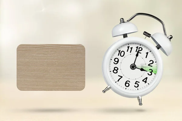 Change time. Summer time concept, on a wooden background. A white alarm clock with a minute hand indicates that the time has been moved forward an hour with copy space