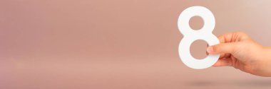 Elde sekiz. Kırmızı arka planda beyaz 8 numarayı tutan bir el. Sekiz numara ile kavram. Doğum günü 8 yıl, yüzde, sekizinci sınıf ya da gün, uluslararası kadınlar günü
