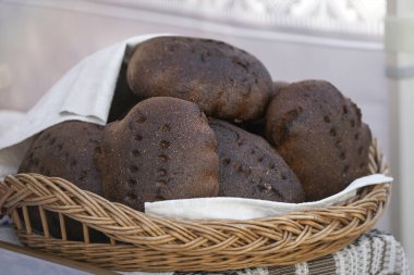 Siyah taze ev yapımı ekmek. Bir fırının tezgahında bir somun siyah çavdar ekmeği parçalara ayrılır. Siyah ekolojik ekmek dokusu.