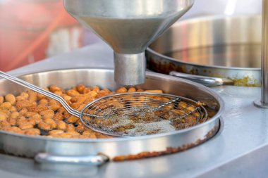 Lokma pişirme işlemi, aşçı lokma 'yı kızartma makinesinde pişirir. Kızarmış hamur toplarından yapılan popüler bir Orta Doğu tatlısının endüstriyel üretimi. Küçük çörekler.