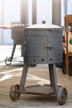 Yerde yakacak odunları olan demir bir tütsü evi var. Tütsühanede, çeşitli sağlıklı yiyecekler içebilirsiniz. Küçük işletme sigara konsepti. Yüksek kalite fotoğraf