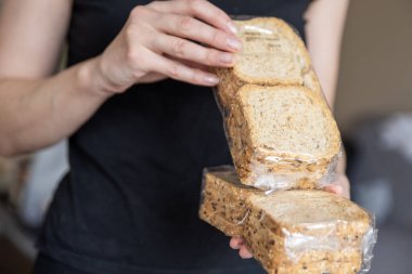 Bir el iki paket ekmek tutar. Sandviç hazırlama süreci. Atıştırmalık hazırlıyorum. Yüksek kalite fotoğraf