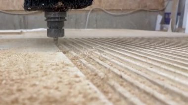 CNC endüstriyel makinesi odun öğütüyor. Ahşap işçiliği makinesi ahşap tahtanın yüzeyine nüfuz ediyor. Yakın plan mobilya parçaları fabrikada öğütülüyor.