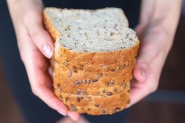 Kadınların elleri ekmeği yakın planda tutuyor. Taze sandviç hazırlama süreci. Yüksek kalite fotoğraf