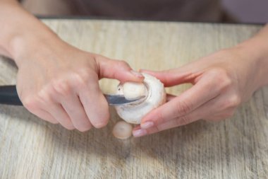 Mantar soyma işlemi. Bir kadının elleri mantarları bıçakla soyar, yakın plan. Mantar pişiriyorum. Yüksek kalite fotoğraf