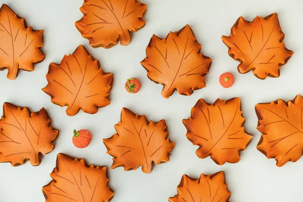 stock image Gingerbread cookies with orange icing in the shape of fallen autumn leaves freshly baked out of the oven. Thanksgiving Day or Halloween festive background. Flat lay. White background