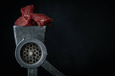 Biftek köfteleri için kıyma yapmak siyah arka planda elle kıyma makinesinde. Makro atış. Metal et öğütücüsünü çiğ etle kapatın.