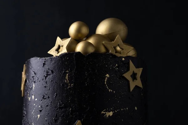 黄金のチョコレートの星と球で飾られたダークブルーのクリームチーズの霜付きの高級ケーキ 黒を基調とした誕生日空間ケーキ — ストック写真