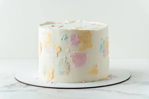 白い背景に多色のスミアで飾られた白いクリームチーズの霜が付いているケーキ 空のケーキとともにフリースペースのためのテキスト — ストック写真