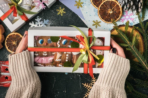 여자들 이손에는 장식을 진저브레드 남자들이 상자를 전통적 크리스마스 쿠키를 메이드한다 — 스톡 사진