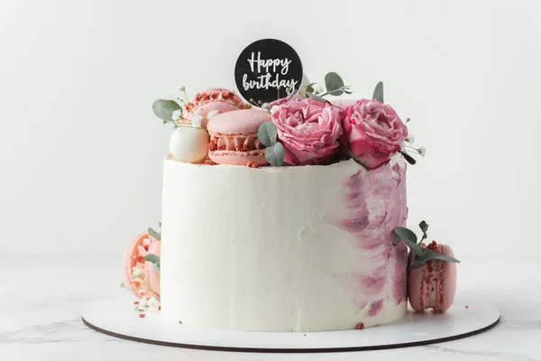 生日蛋糕 白色的奶油奶酪泡沫装饰着红玫瑰和粉红的金黄色背景 结婚周年蛋糕祝你生日快乐 — 图库照片