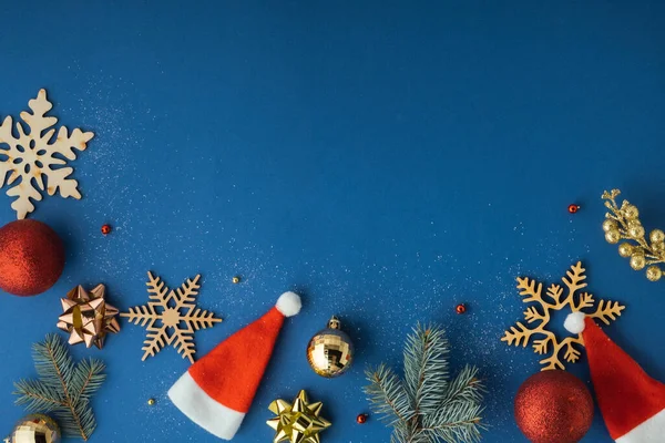 파란색 배경에 크리스마스 장난감 크리스마스를 배경으로 눈송이 나뭇가지 모자등 평평하게 — 스톡 사진