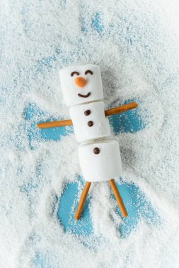 Mavi arka planda kar kaplı lokum kardan adam. Düz yatıyordu. Uzayı kopyala Noel beklentisi. Kış konsepti