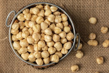 Çuval besin konseptinde metal bir kasede soyulmuş fındık yığını. Geleneksel kırsal tarım geçmişi. Düz yatıyordu