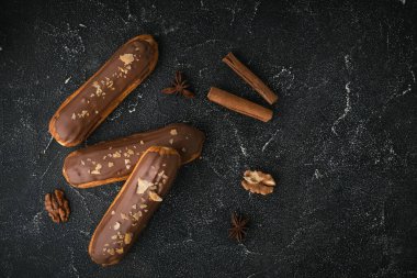 Kremalı pasta ve siyah beton kaplama çikolatalı krema. Geleneksel Fransız pastası. Erimiş sütlü çikolatayla kaplı kremalı ekler. Düz yatıyordu