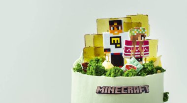 KYIV, UKRAINE - 11 Aralık: Minecraft oyununun beyaz arka plandaki bir hayranı için doğum günü pastası. Yenilebilir yeşil çimenler ve karamelli şekerlerle süslenmiş bir av köpeği için kek.