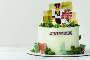KYIV, UKRAINE - 11 Aralık: Minecraft oyununun beyaz arka plandaki bir hayranı için doğum günü pastası. Yenilebilir yeşil çimenler ve karamelli şekerlerle süslenmiş bir av köpeği için kek.