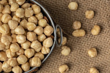 Çuval besin konseptinde metal bir kasede soyulmuş fındık yığını. Geleneksel kırsal tarım geçmişi. Düz yatıyordu