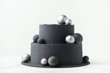 Beyaz arka planda çikolatalı kadife kaplamalı lüks siyah ranza pastası. Gümüş çikolata küreleriyle süslenmiş siyah kadife desenli doğum günü pastası.