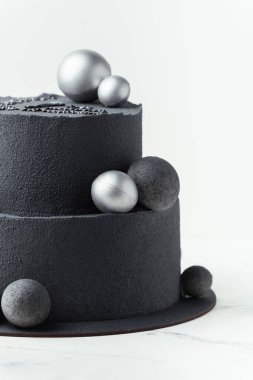 Beyaz arka planda çikolatalı kadife kaplamalı lüks siyah ranza pastası. Gümüş çikolata küreleriyle süslenmiş siyah kadife desenli doğum günü pastası.