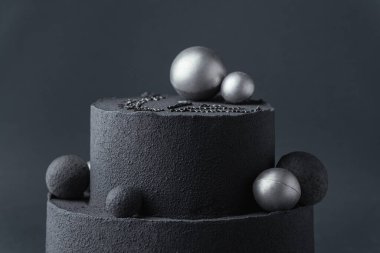 Koyu gri arka planda çikolatalı kadife kaplı lüks siyah ranza pastası. Gümüş çikolata küreleriyle süslenmiş siyah kadife desenli doğum günü pastası.