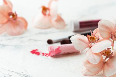 Making edible orchid sugar flowers with powdered dyes on the white marble background. Macro shot