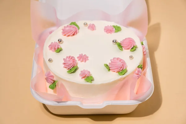在米色背景的白色礼品盒中 装饰着粉红乳酪花的韩国风格的小本托蛋糕 蛋糕是送给心爱的人的礼物一个女人的春嫩蛋糕 顶部视图 — 图库照片