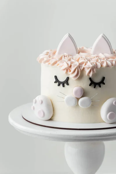 白い背景に食用のまぶた 耳と魔法の足で飾られた小さな女の子のための猫のケーキ 白とピンクのクリームチーズの霜降り誕生日ケーキ — ストック写真