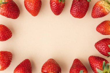 Bej arkaplanda taze kırmızı çilek manzarası ve bedava metin için fotokopi alanı. Yaz meyveleri dokulu arka plan. Düz yatıyordu