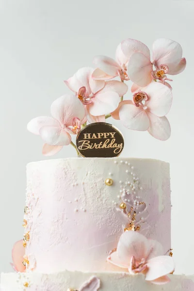 ピンクと白のクリームチーズと結婚式の二段ケーキ食用蘭の砂糖の花と白の背景に黄金の花びらで飾られた霜降り — ストック写真