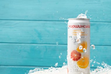 KYIV, UKRAINE - 13 Mayıs: Turkuaz arka planda Morshynska portakal aromalı içecek kutusunun üzerine su sıçraması yakın çekim. Popüler Ukrayna meşrubat reklamı. Yazın soğuk, ferahlatıcı bir içecek..