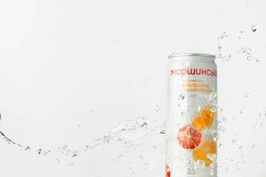KYIV, UKRAINE - 13 Mayıs: Beyaz arka planda Morshynska portakal aromalı içecek kutusunun üzerine su sıçraması yakın çekim. Popüler Ukrayna meşrubat reklamı. Yazın soğuk, ferahlatıcı bir içecek..