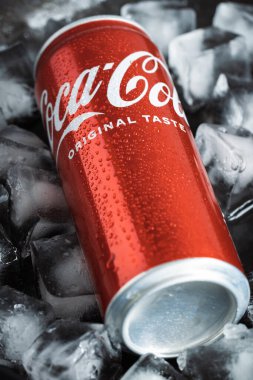KYIV, UKRAINE - 09 Mayıs - Siyah arkaplandaki buz küplerinin içinde klasik Coca-Cola kırmızı kutusunu yakın çekim. Coca-Cola şirketinin popüler içeceği. Sıcak yaz konsepti sırasında soğuk içecek.