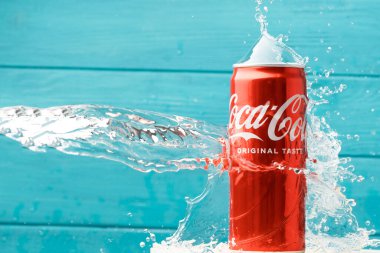 KYIV, UKRAINE - 13 Mayıs: Turkuaz ahşap arka planda klasik Coca-Cola kırmızı kutusunun üzerine su sıçraması yakın çekim. Meşrubat reklamı. Yazın soğuk, ferahlatıcı bir içecek..