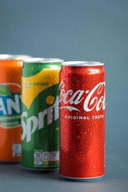 KYIV, UKRAINE - 09 Mayıs - Gri arkaplanda klasik Coca-Cola, Sprite ve Fanta kutularının yakın çekimi. Coca-Cola şirketinin popüler ürünleri. Soğuk içecek konsepti