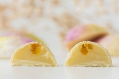 Ev yapımı çikolatalı bonbon dilimleri. Elle boyanmış şekerler. İkiye bölünmüş şeker. Fotokopi alanı olan bir model. Beyaz arkaplanda çikolatalı ürünlerin makro görüntüsü