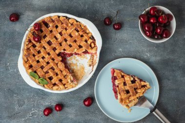 Gri beton zemin üzerine şeker serpiştirilmiş ev yapımı vişneli turta. Geleneksel Amerikan kirazlı turtası. Düz yatıyordu