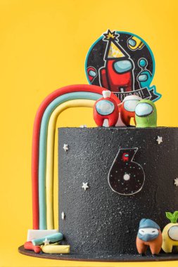 KYIV, UKRAINE - 26 Temmuz: Online bilgisayar oyunu karakterleri şeklinde mastik figürlerle süslenmiş siyah çikolata kadife kaplamalı doğum günü pastası. Sarı arka planda bizim temalı pastamız