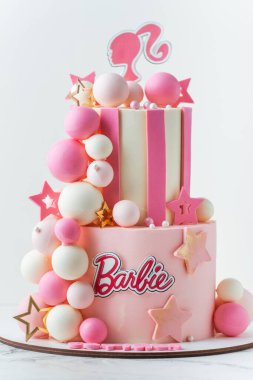 KYIV, UKRAINE - 07 Ekim: Çikolata küreleriyle süslenmiş pembe çikolatalı Barbie bebek pastası. Beyaz arka plandaki bir kız için doğum günü pastası.