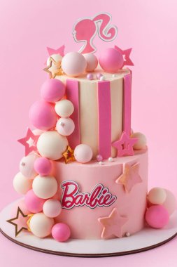 KYIV, UKRAINE - 07 Ekim: Çikolata küreleriyle süslenmiş pembe çikolatalı Barbie bebek pastası. Pembe pastalı arka planda bir kız için doğum günü pastası.