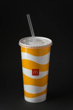 KYIV, UKRAINE - Ocak 06: Soğuk McDonald 's siyah arka planda plastik kapaklı ve samanlı bir kağıt bardakta içki. Popüler fast food restoranı.