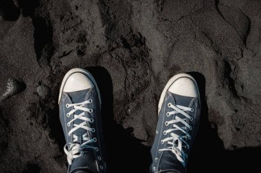 Tenerife, Kanarya Adaları, İspanya 'daki siyah kumsalda yürüyen erkek ayakkabılarının yukarıdan görünüşü