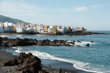 Siyah kumları ve siyah volkanik kayaları olan güzel bir sahil. Okyanus yakınlarındaki tropik tatil köyü manzarası. Playa Jardin, Puerto de la Cruz, Tenerife, İspanya