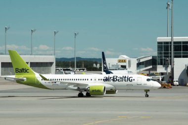 MUNICH, GERMANY - 27 Nisan: Airbus A220-300 uçakları Münih Havalimanı 'nda açık yeşil üniformalı. Modern yolcu uçağı güneşli bir günde vergileniyor.