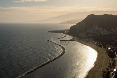 Las Teresitas sahilindeki sarı kumlu günbatımının manzarası. Güneş ışığı, gün batımında denize yansıyor Santa Cruz de Tenerife şehri yakınlarındaki güzel sahilde, Kanarya Adaları 'nda.