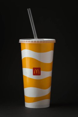 KYIV, UKRAINE - Ocak 06: Soğuk McDonald 's siyah arka planda plastik kapaklı ve samanlı bir kağıt bardakta içki. Popüler fast food restoranı.